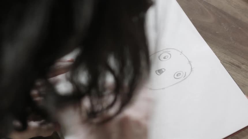 A woman flipping back and forth between two drawings to create an animation