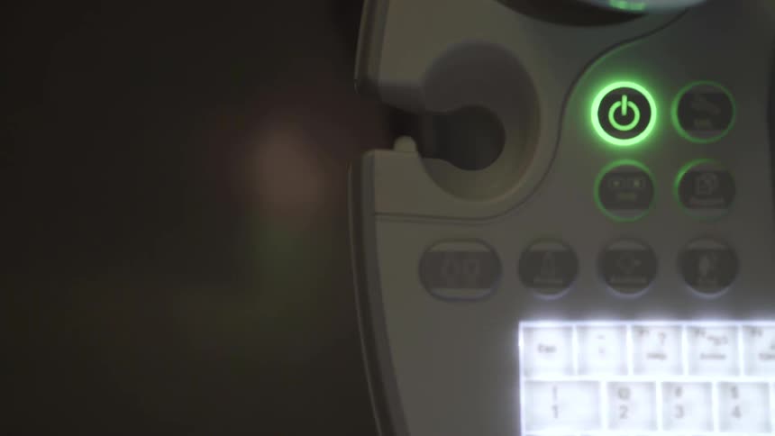 A power button is lit up green above a virtual keyboard on a device