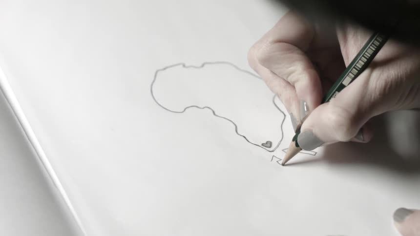 A person is drawing with a pencil on paper