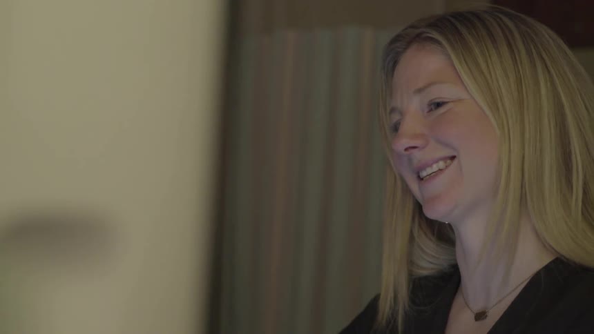 A woman smiles and talks