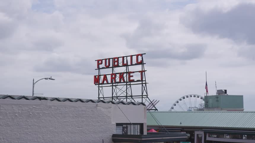 Signage of a market place with ferris wheel in the background