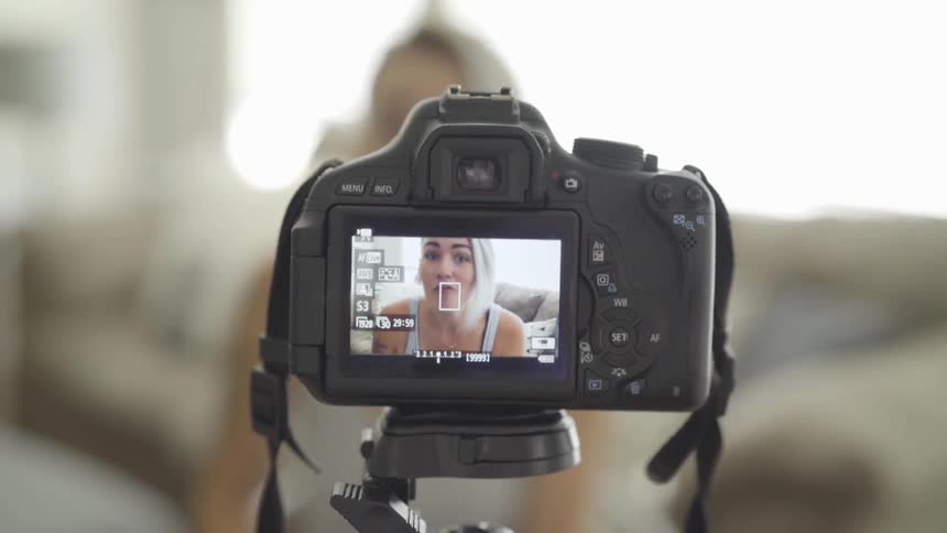 A woman is video taping herself indoors