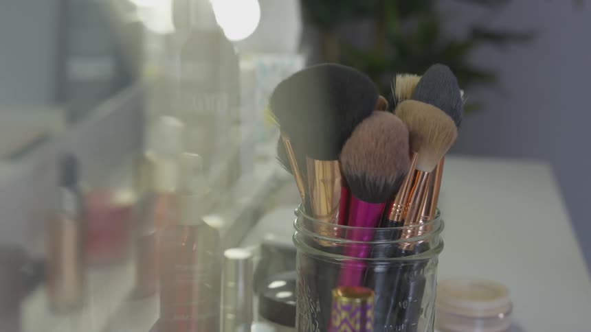 Makeup brushes and makeup sit on a vanity