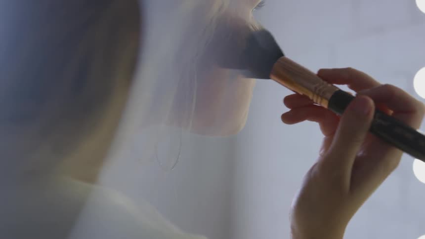 A woman smoothing out her makeup