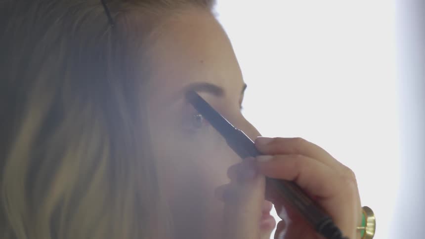 Woman colors in eyebrows
