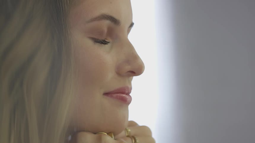 A woman is closing her eyes and then opening them