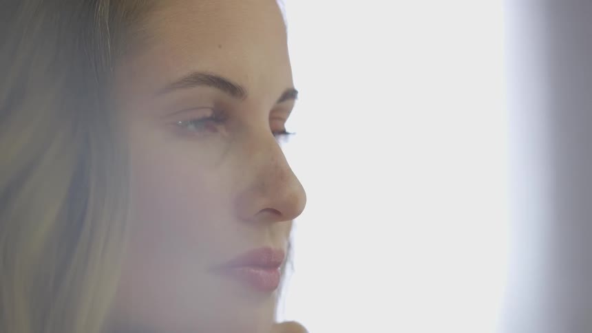 A woman looks at something intently and smirks