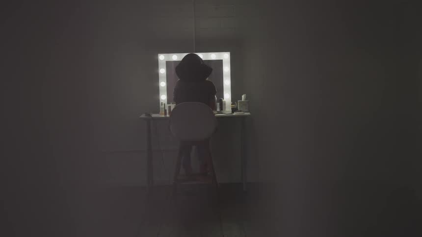 A woman is looking at herself in the mirror