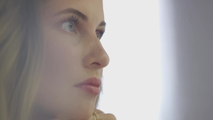 White woman blinking and then holding eyes wide open