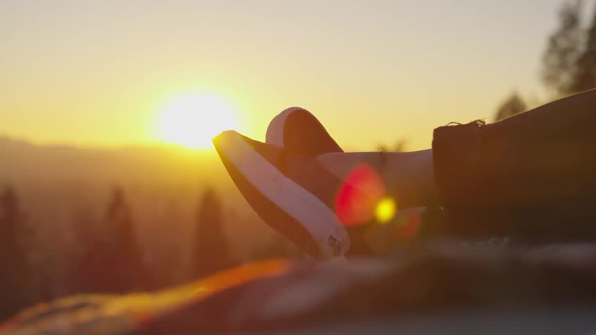 A person reclines on the top of a mountain