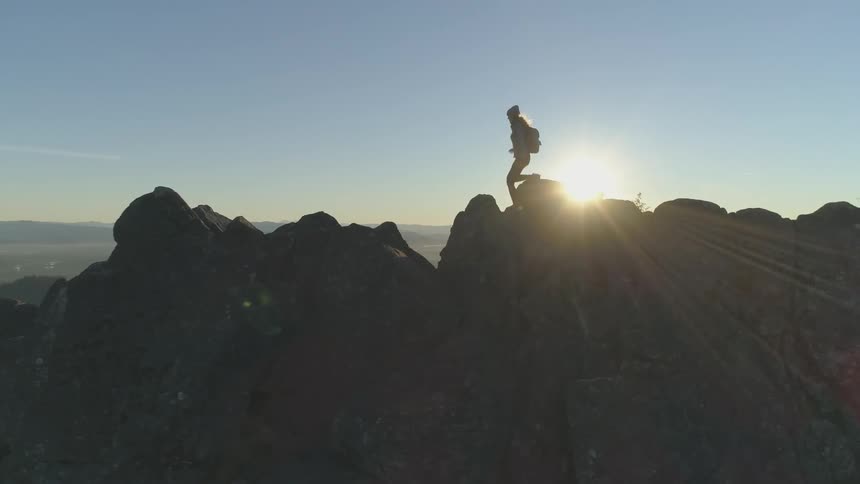 Woman hikes along rocky mountain top
