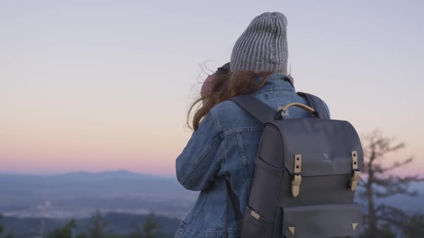 Woman takes picture of mountains in the distance