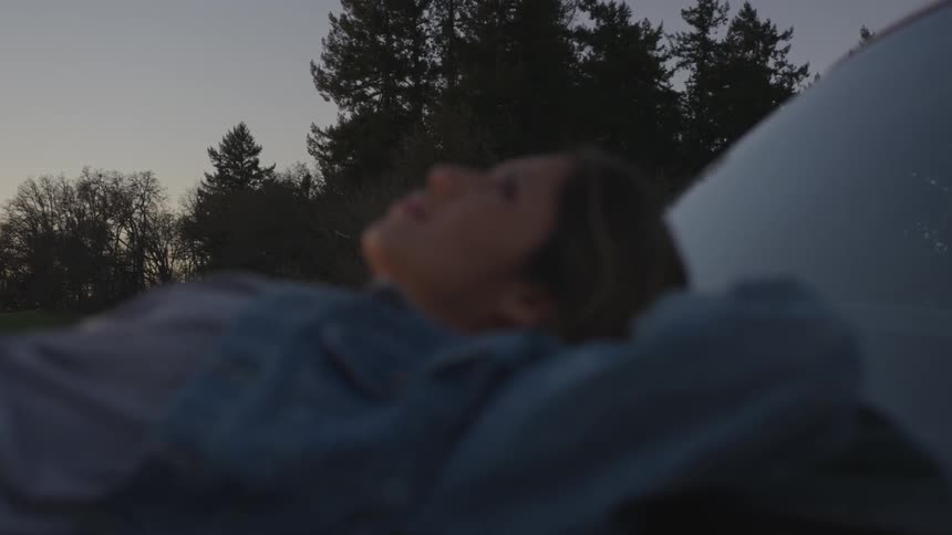 A woman lies outside looking up at the sky