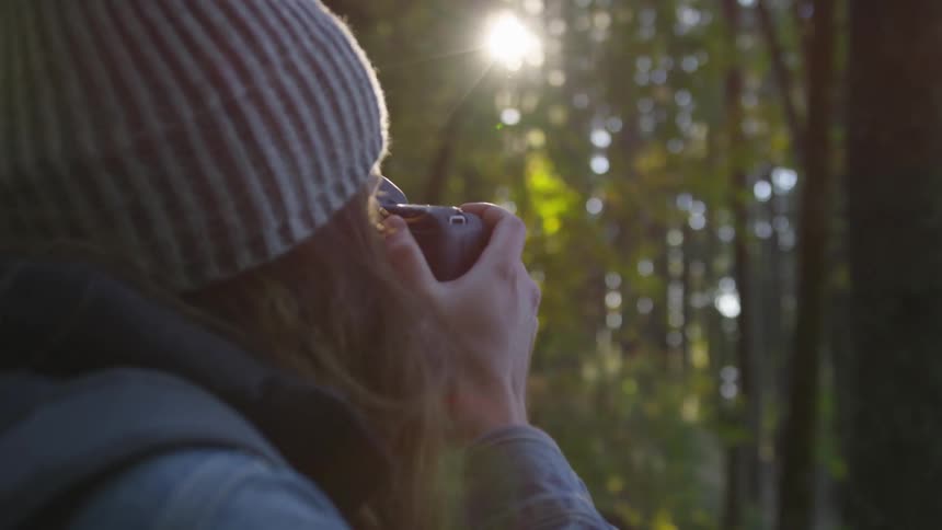 Woman taking photographs in the woods