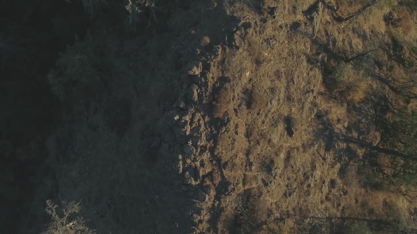 Camera looks down on the mountain covered with grass