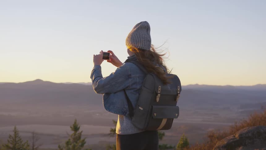 Woman takes a picture of a valley
