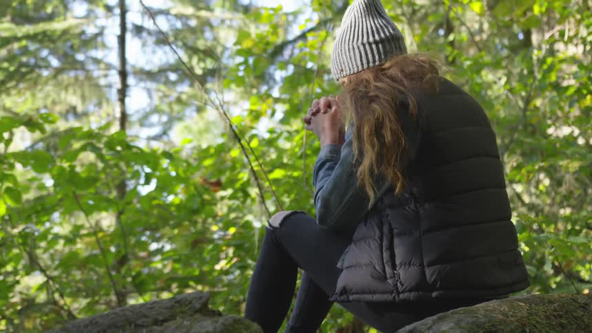 A woman sits in a tree and prayers