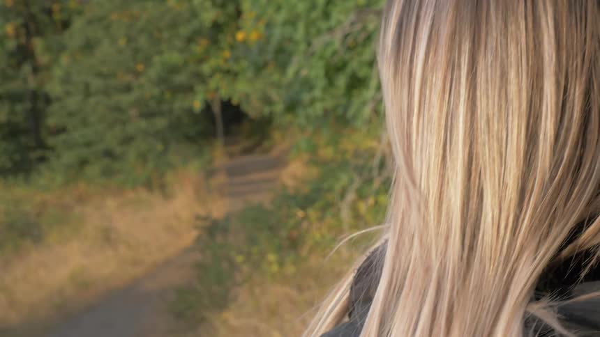 Woman walks along woodland trail