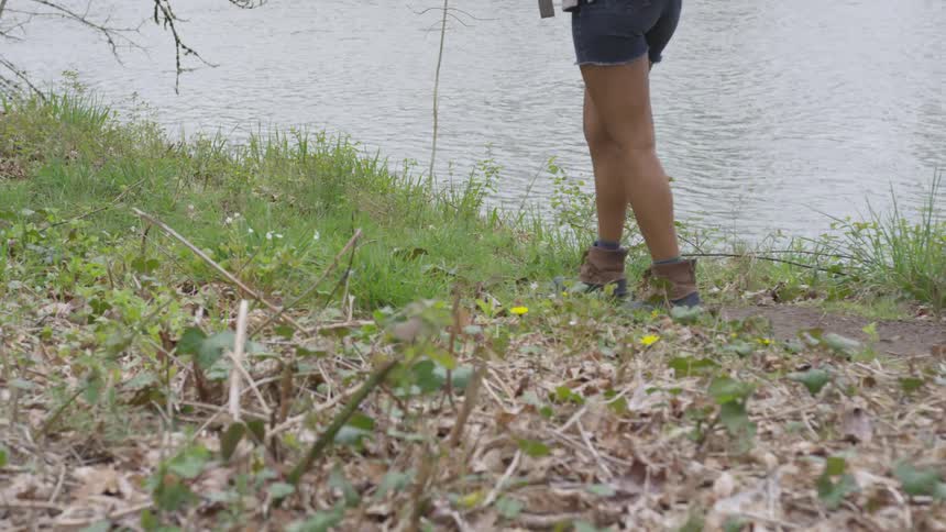 A woman walks along the backs of a lake