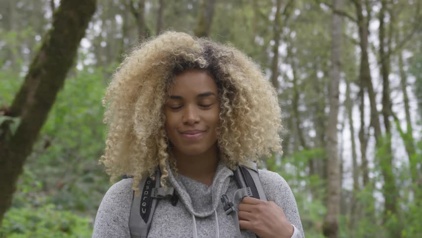 A woman is smiling outdoors