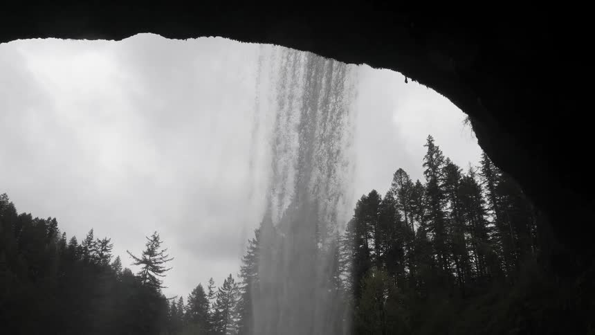 Waterfall flows down on a cloudy day in the forest