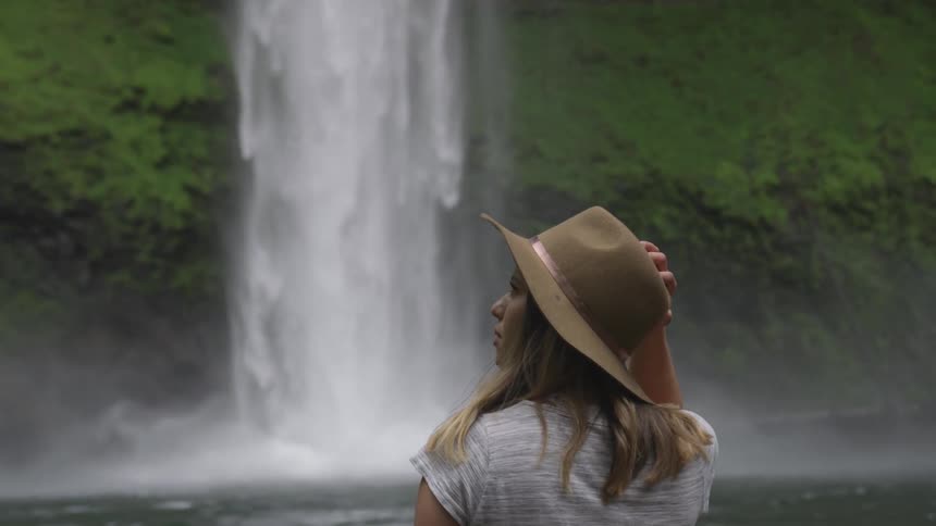 Woman looks at waterfall