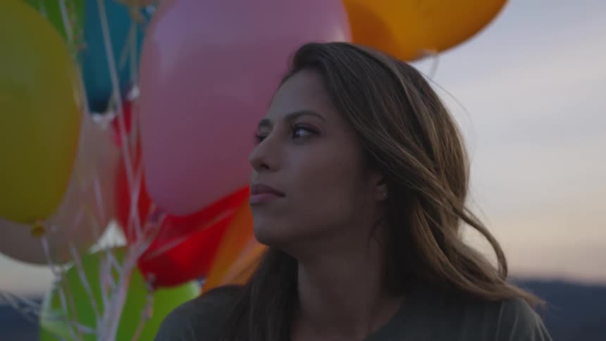 A woman holding a a group of balloons