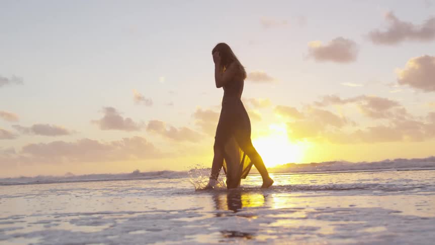 Woman walks through the surf at the beach