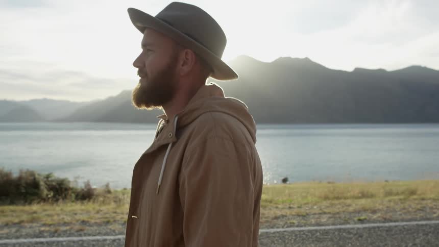 A man is walking along a shore