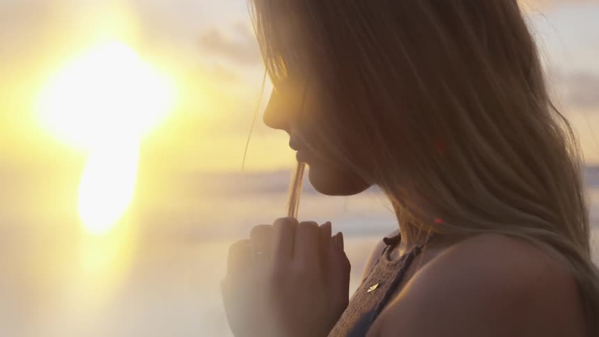 A woman standing outdoors during sunset
