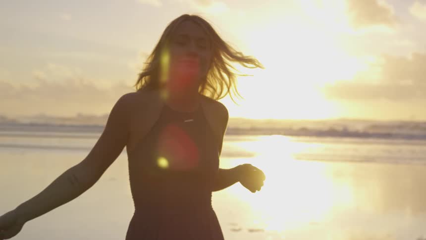 A woman holding a rose with the sun and the sky in the background