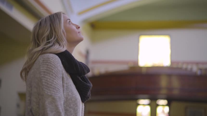 White woman looking at the ceiling of a historic building