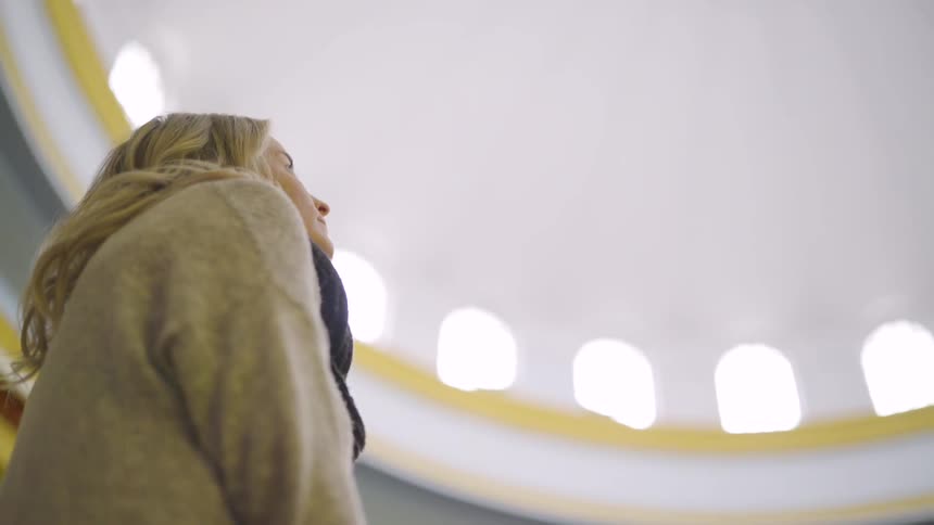 Woman looks up in a dome shaped building