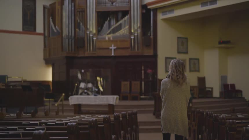 A woman looks around as she walks through the church