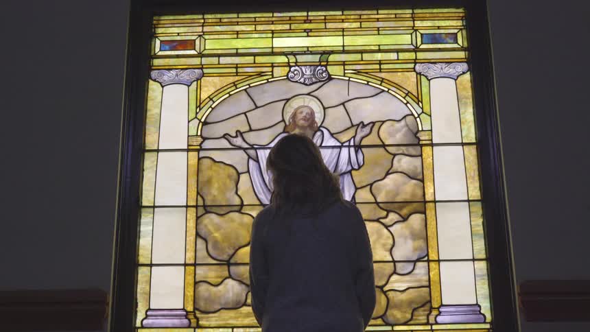 A person staring at a religion stained glass