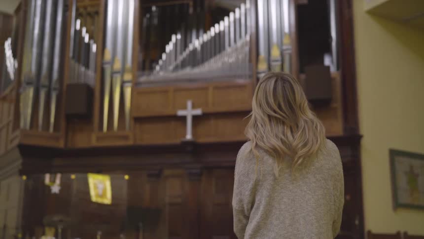 Woman stands in front of an altar in the church