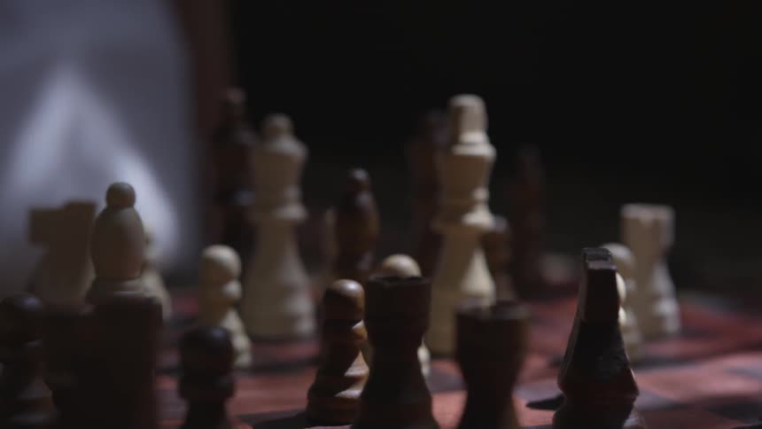 A person pounding on a full chess board