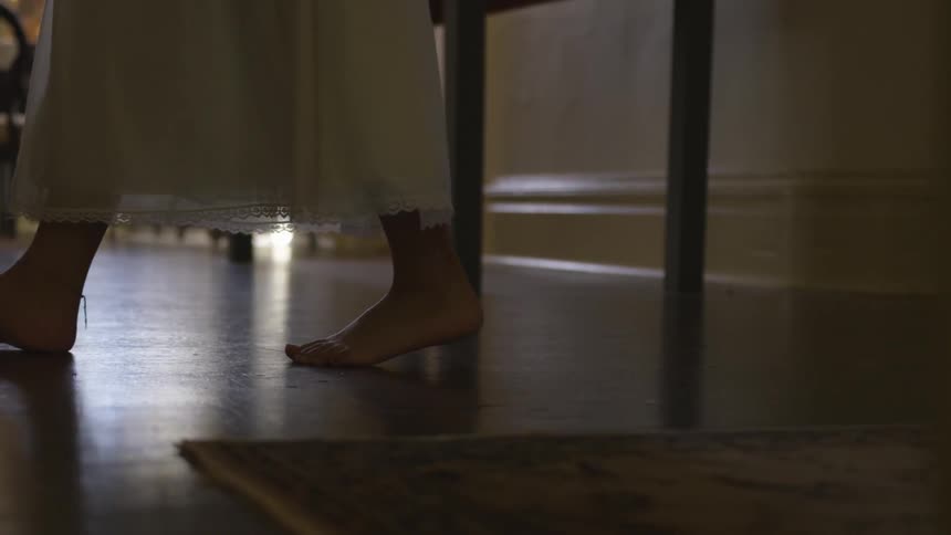 Woman walks across a floor barefoot