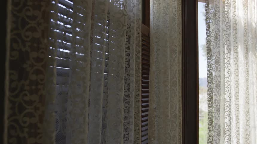 Camera looks at closed curtains in front of a window