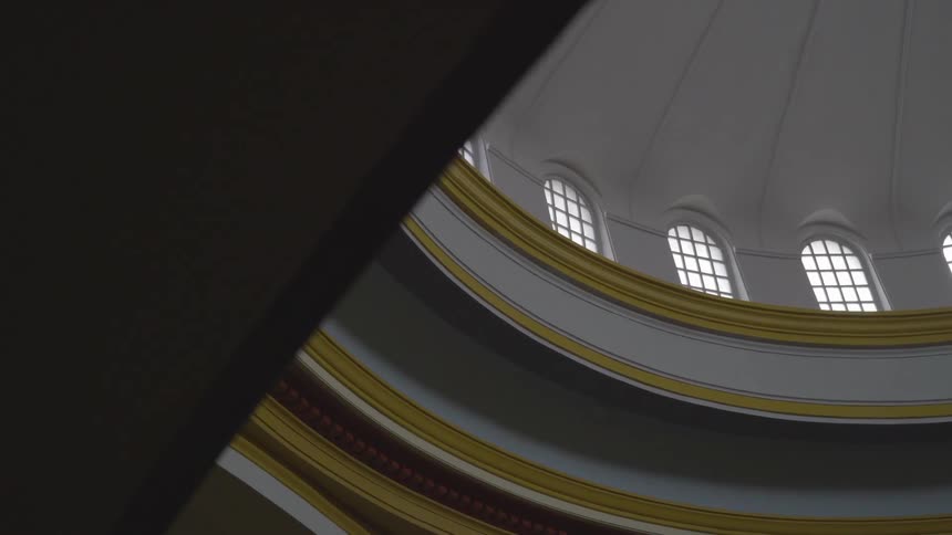 The camera looks up into the dome on top of a large building