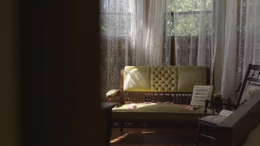 Sun enters sitting room through lace curtains