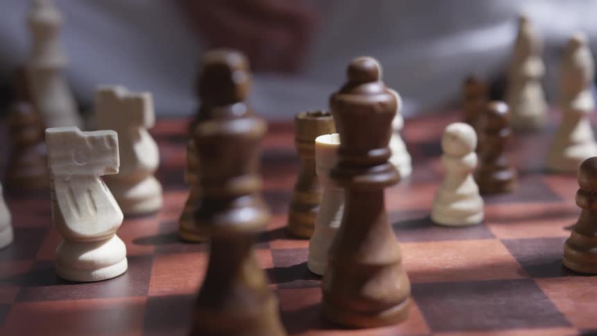 Carved wooden chess pieces on wooden chess board
