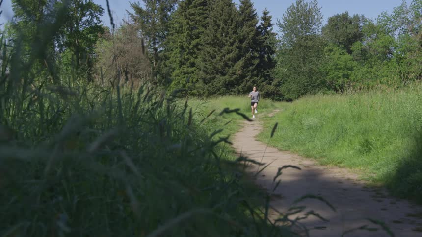 A woman running along a path through a woodland