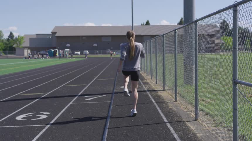 Woman warms up on a running track
