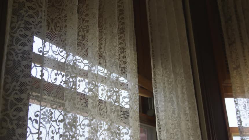 Windows of a house with lace curtains in the daytime