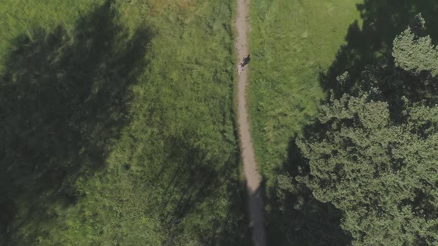 A person runs down a trail through a field