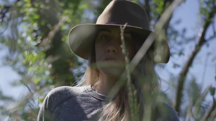 A woman stares at the camera through wild wheat