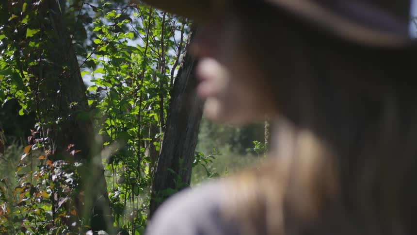 Woman standing outdoors in the wilderness looking to her left