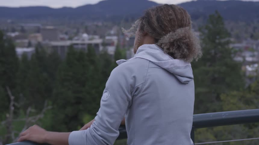 A woman looks out over a city