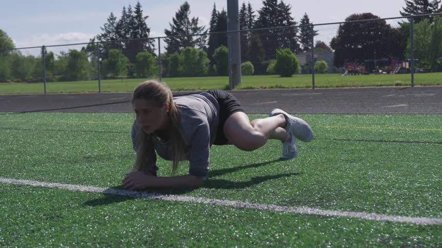 Young woman exercises while holding planking position